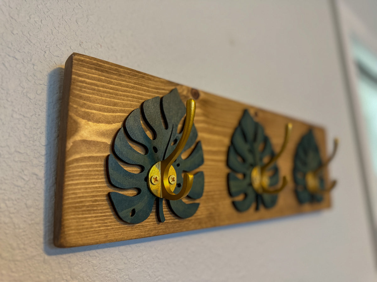 Monstera leaf hook rack mounted on a wall in an entryway
