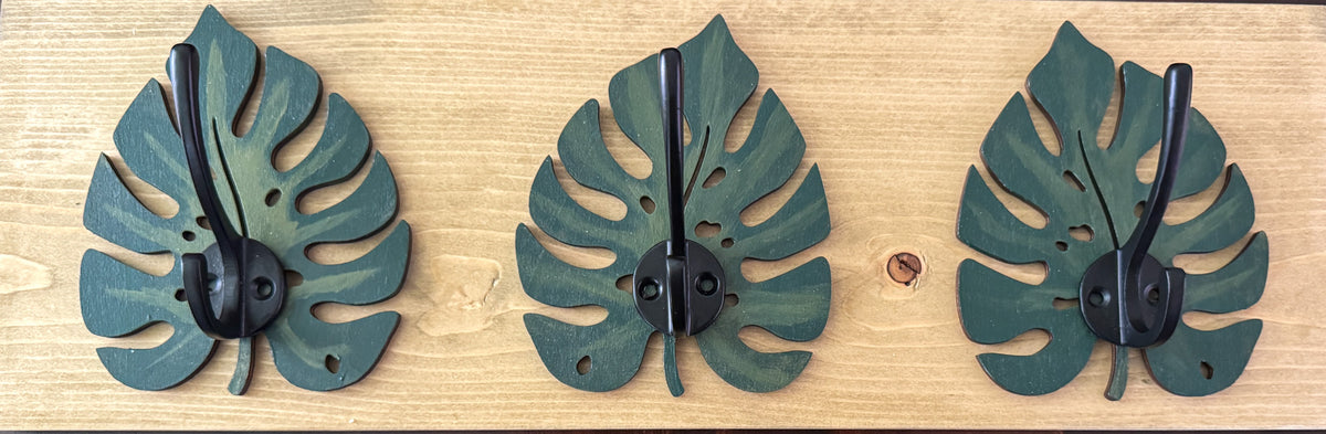 Close-up of gold hook detail on monstera leaf rack