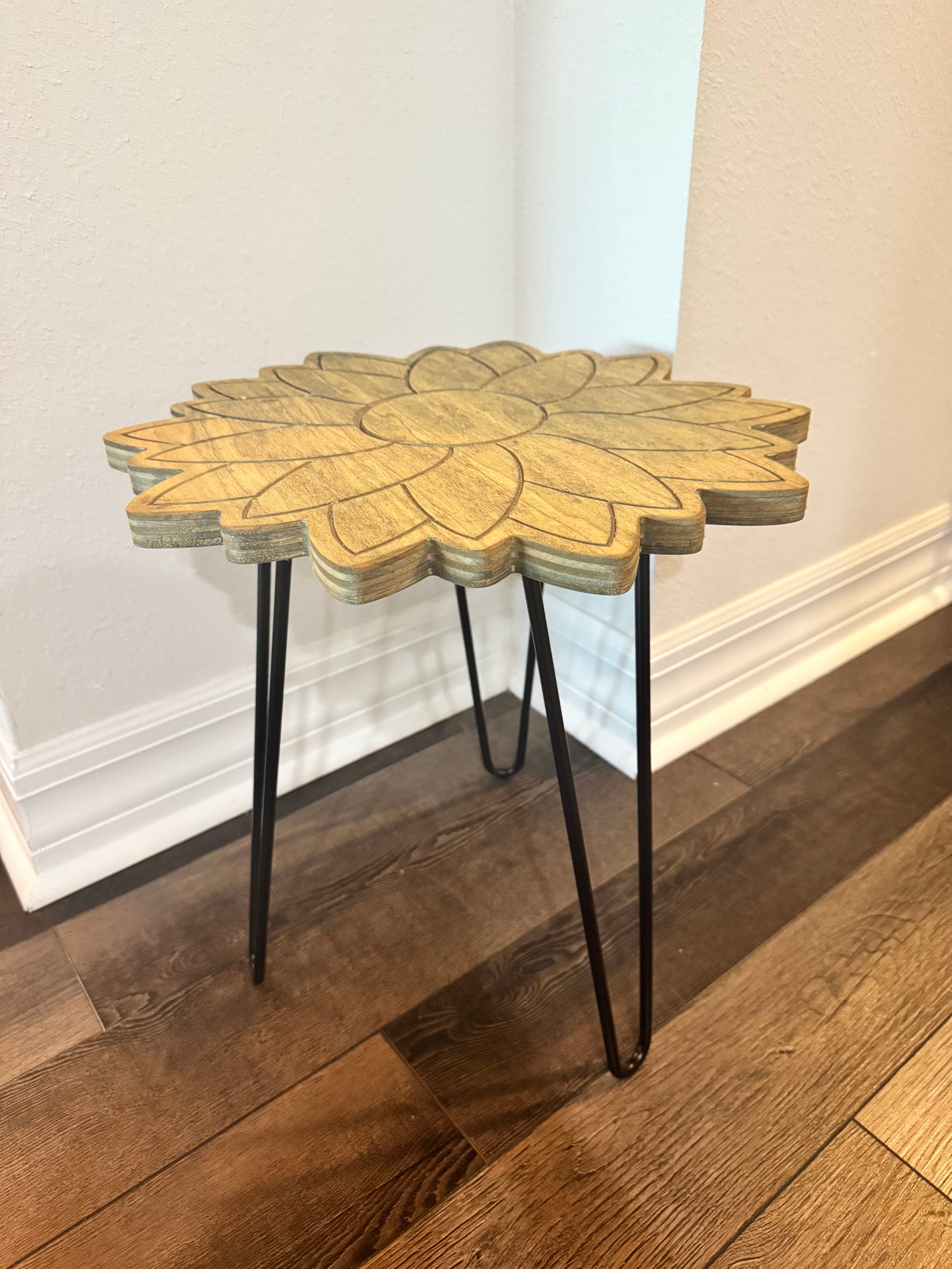 Sunflower-shaped wood plant stand displayed in a room corner