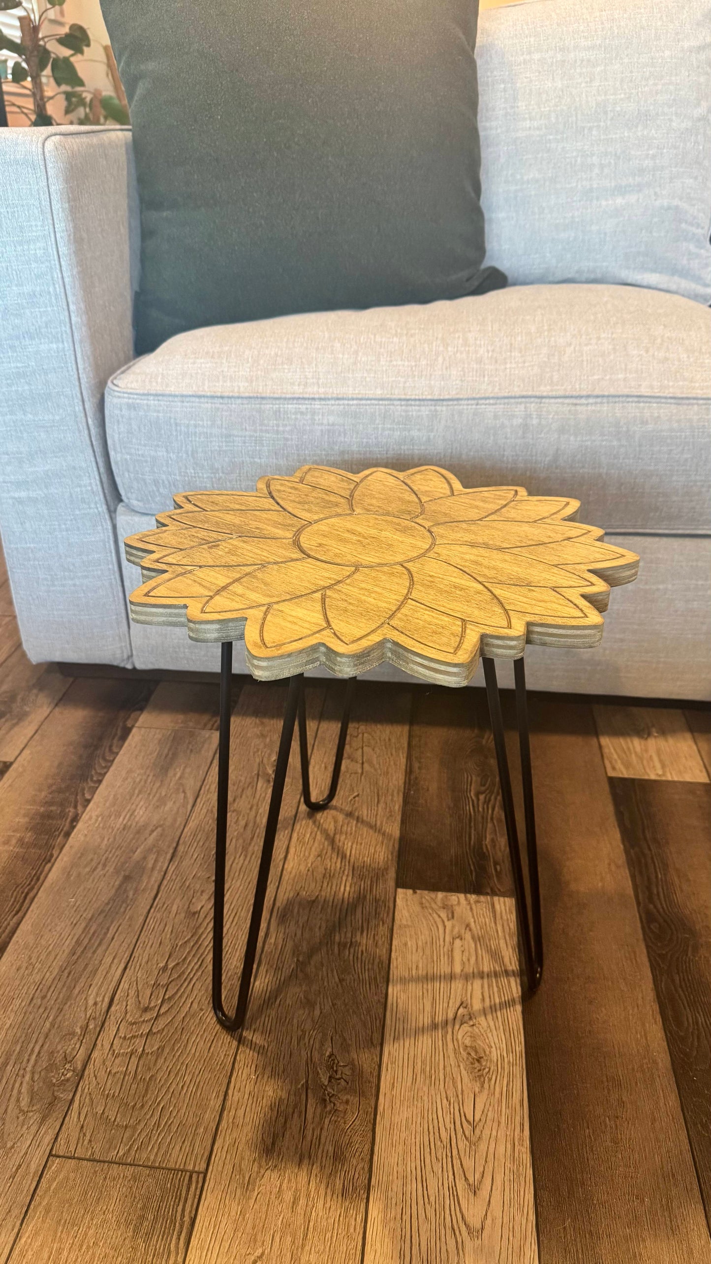 Front view of the wooden sunflower plant stand in a living room