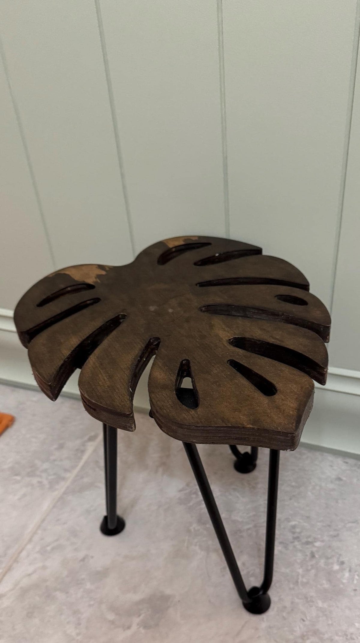Monstera leaf plant stand with a potted plant on top